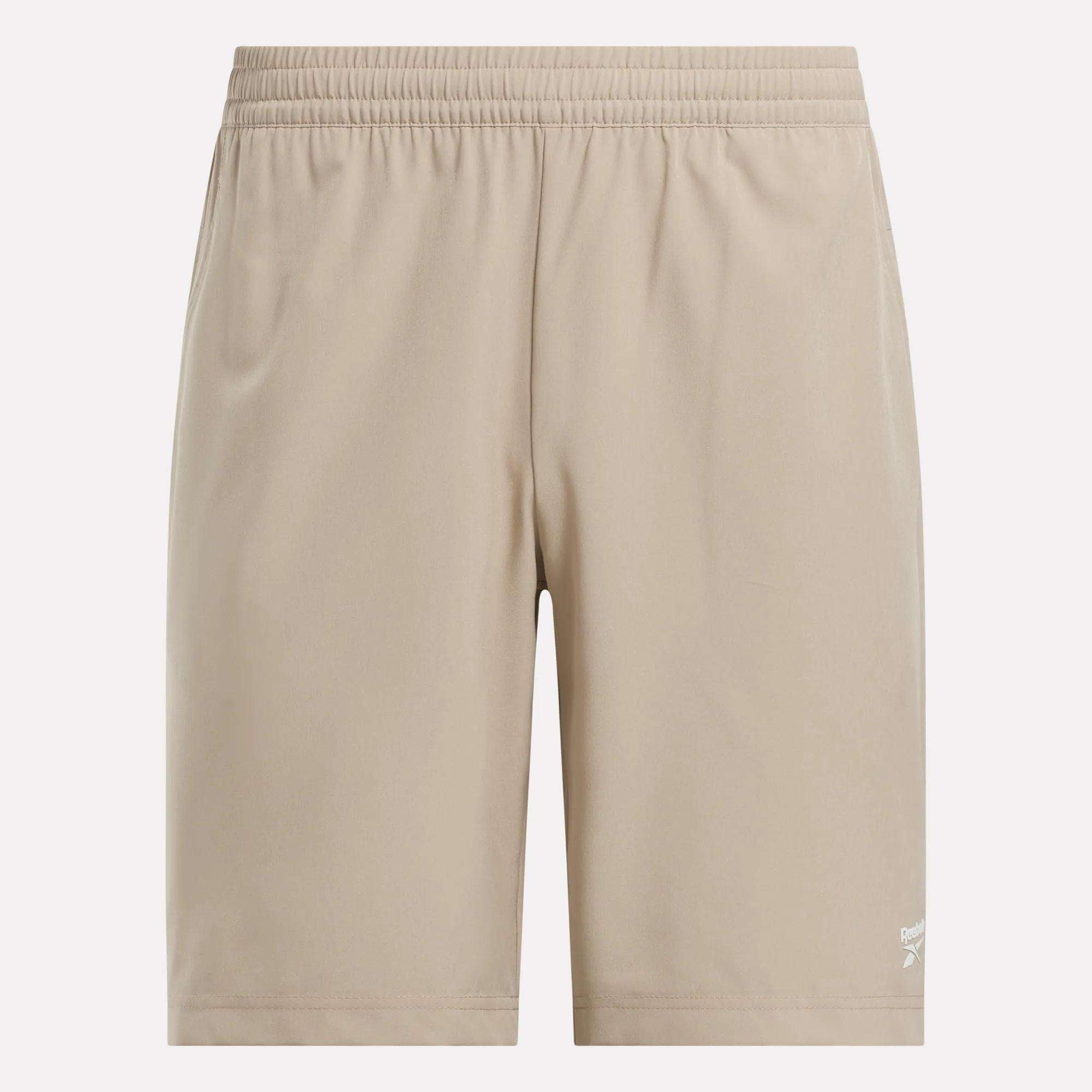 Reebok Men's Range Shorts 9" in beige, featuring an elastic waistband and a small white logo near the left hem. Shown on a white background—ideal for comfortable, everyday gym performance.