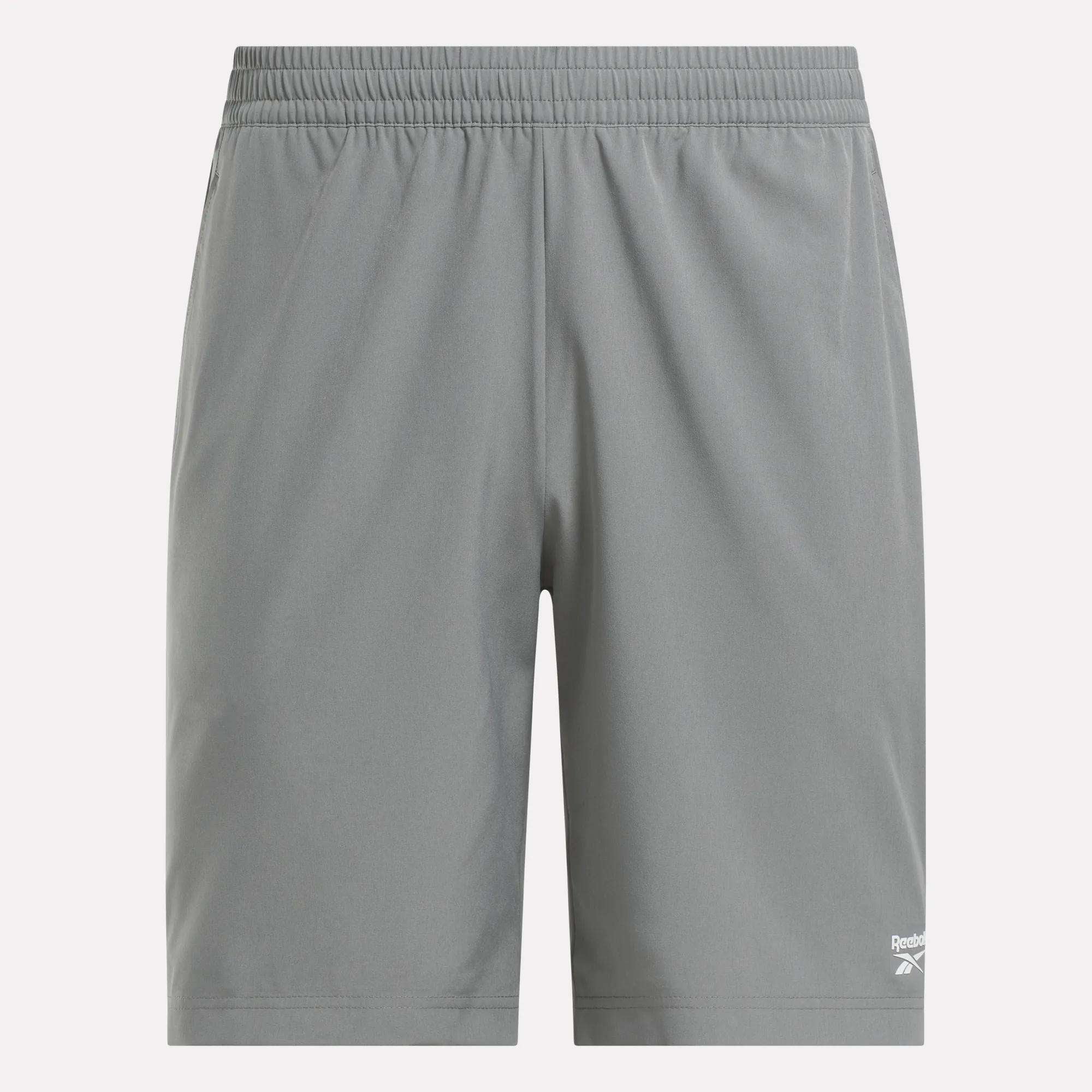 The Reebok Men's Range Shorts 9" are gray gym shorts with an elastic waistband and a small white logo on the bottom left leg. Their lightweight, plain design provides comfort for any workout.