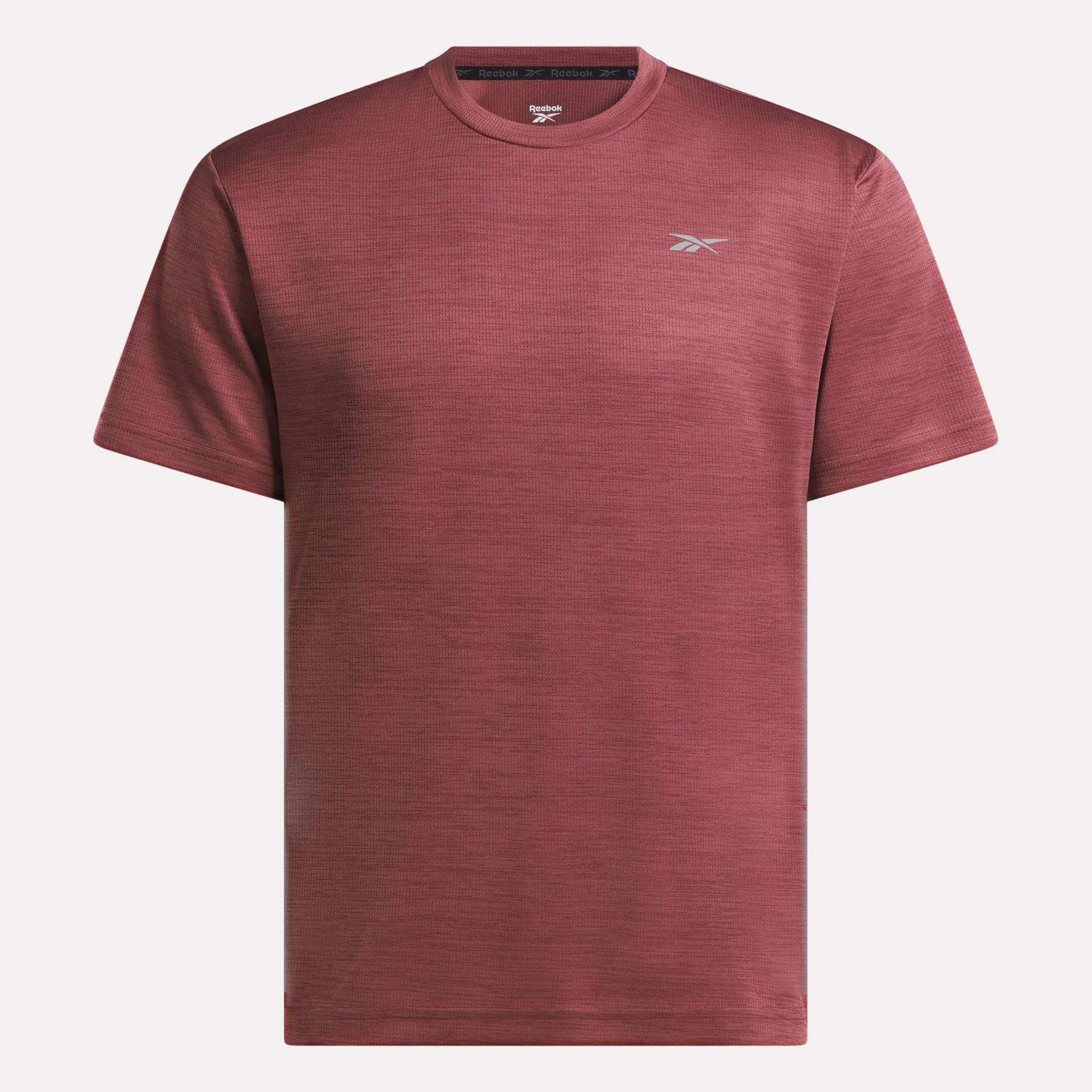 The Reebok Men's Director Short Sleeve Top is a plain maroon training t-shirt with short sleeves and a small white logo on the left chest, shown on a white background. Its stretchy fabric makes it ideal for any workout.