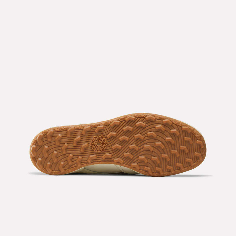 Bottom view of the Reebok x Manors Club C Revenge Golf Shoes, showcasing a textured brown rubber sole with a geometric star pattern at the center and varied tread design for enhanced traction, reflecting the signature attention to detail from both Reebok and Manors.