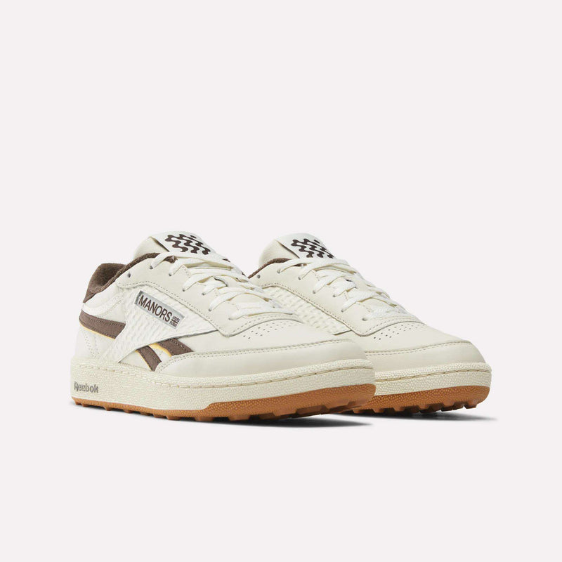 A pair of Reebok x Manors Club C Revenge Golf Shoes in white, featuring beige soles, brown accents, and Manors branding, displayed on a plain white background.