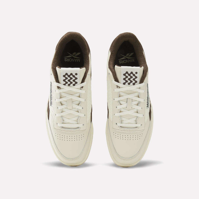 A pair of cream and brown Reebok x Manors Club C Revenge Golf Shoes viewed from above, featuring white laces, perforated toes, and the Reebok brand name on the tongue and side.