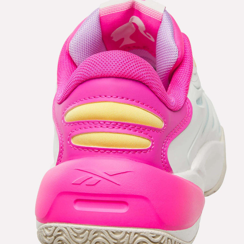 A close-up rear view of the Reebok x Barbie x Angel Reese 1 Shoes for big kids shows off a white and pink basketball design with yellow accents, a textured outsole, and the iconic Reebok logo embossed near the heel—ideal for fans of Angel Reese or anyone eager to channel their inner Barbie in style.