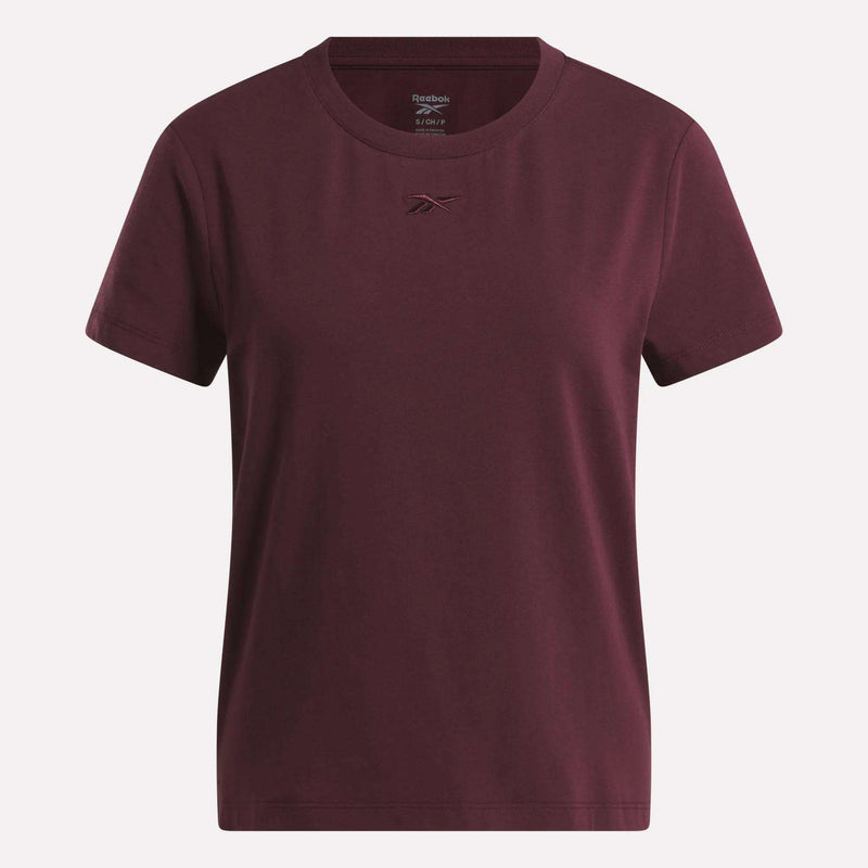 The Women's Graphic Glow Top by Reebok is shown on a white background, featuring a classic maroon design with a small embroidered logo on the chest.