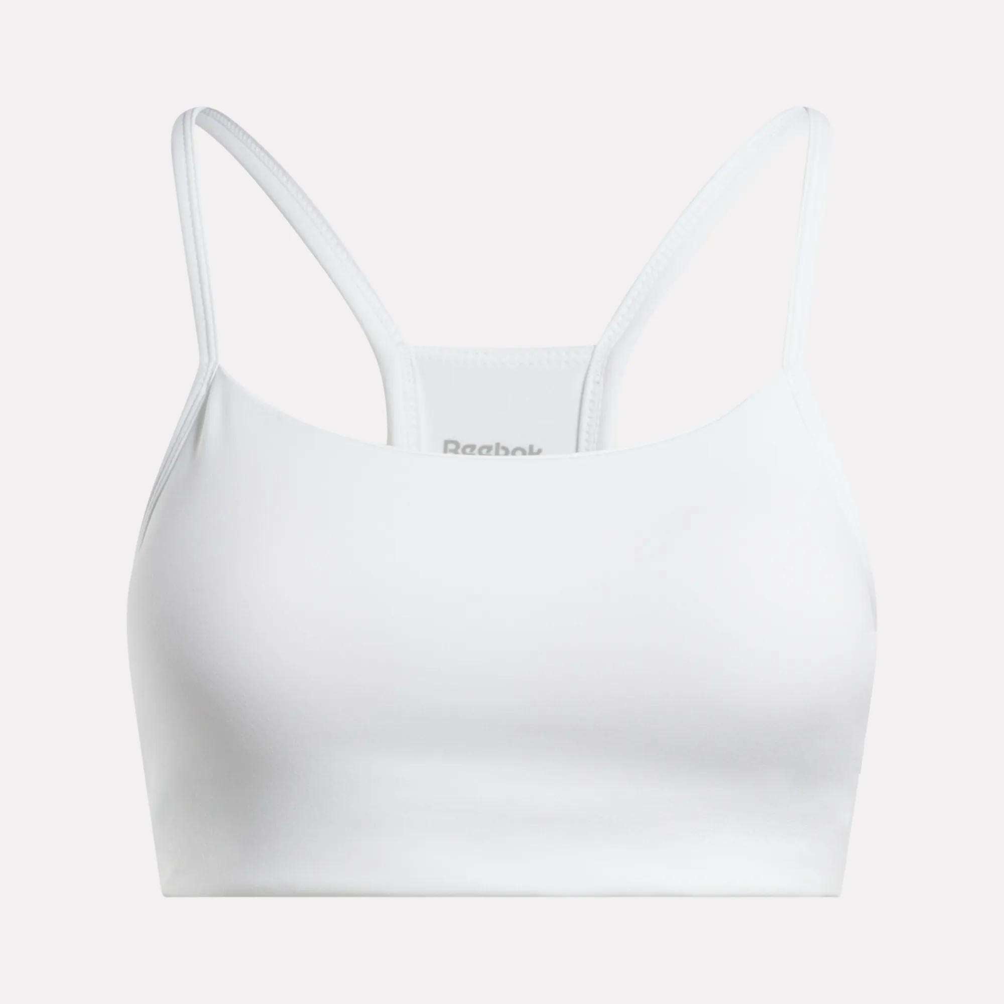 The Reebok Women's Low-Impact Sports Bra features thin shoulder straps and a racerback design in white, ideal for light-impact workouts and shown against a light background.