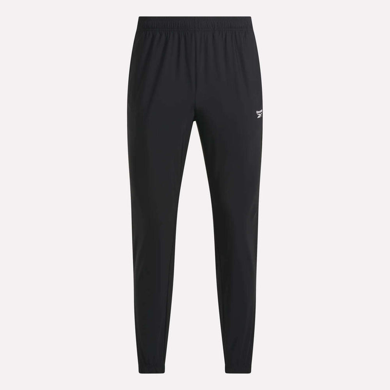 Men’s Repeat Pants by Reebok feature a black, slim-fit design with an elastic waistband and cuffs. These athletic track pants display a small white Reebok logo on the upper left thigh and are designed without visible pockets or drawstrings.