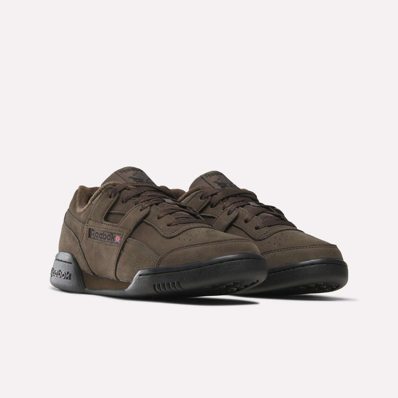 A pair of brown Reebok Workout Plus Shoes featuring laces, black soles, and the signature Reebok logo on the side, displayed against a clean white background—the perfect option for those in search of timeless sneakers.