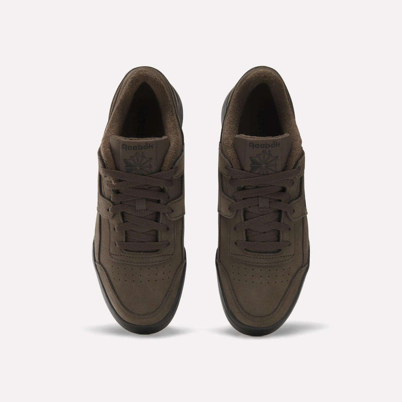 A pair of brown Reebok Workout Plus Shoes viewed from above, featuring laces, perforated toe boxes, and the Reebok logo on the tongues, set against a plain light background—these iconic Reebok sneakers effortlessly blend style and comfort.