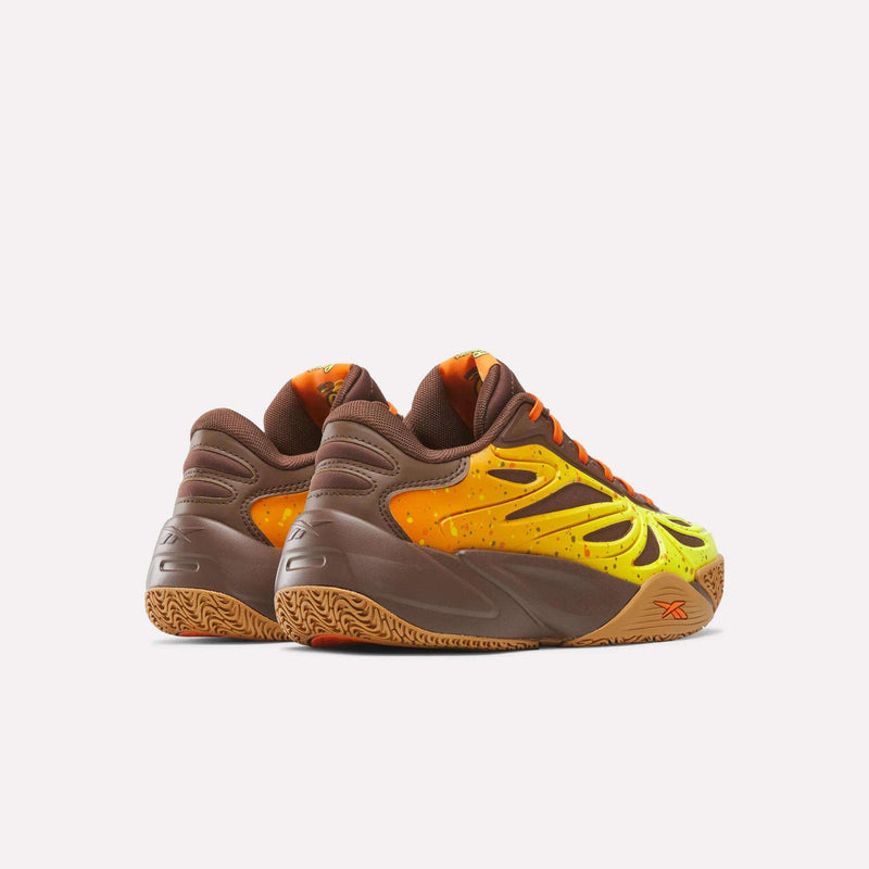 A pair of Reese’s x Angel Reese 1 Basketball Shoes for big kids by Reebok, featuring brown, yellow, and orange gradient uppers, brown soles, and orange accents with performance innovation details, displayed on a plain white background.