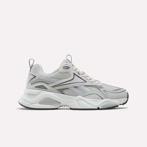A pair of Reebok Men’s Charge Shoes in grey, featuring a chunky cushioned midsole, mesh upper, and wavy black and silver accents, displayed on a plain white background.