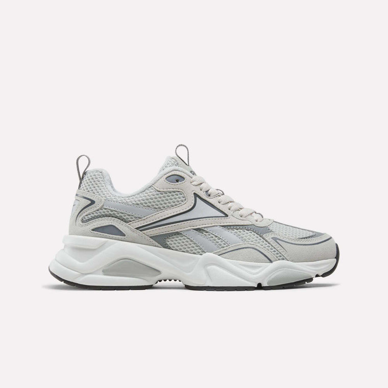 A pair of Reebok Men’s Charge Shoes in grey, featuring a chunky cushioned midsole, mesh upper, and wavy black and silver accents, displayed on a plain white background.