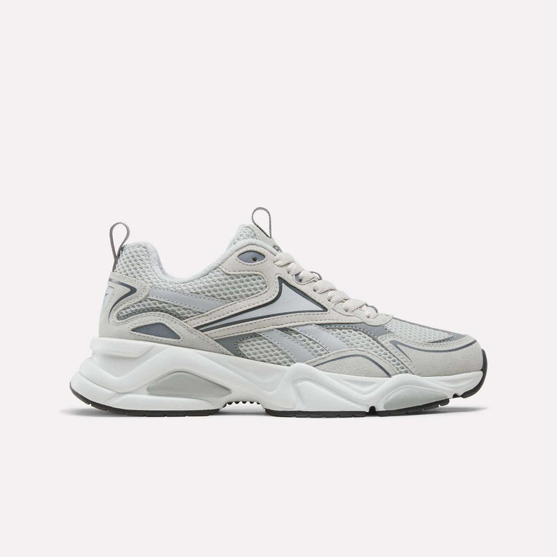 A pair of Reebok Men’s Charge Shoes in grey, featuring a chunky cushioned midsole, mesh upper, and wavy black and silver accents, displayed on a plain white background.