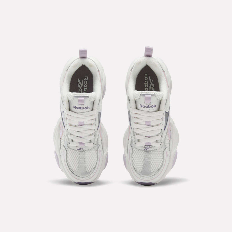 A pair of Women’s Charge Shoes by Reebok in white and lavender, viewed from above, displaying mesh-textured toes, lace-up fronts, and Reebok branding on the tongues and insoles—the perfect training shoes for your next workout.