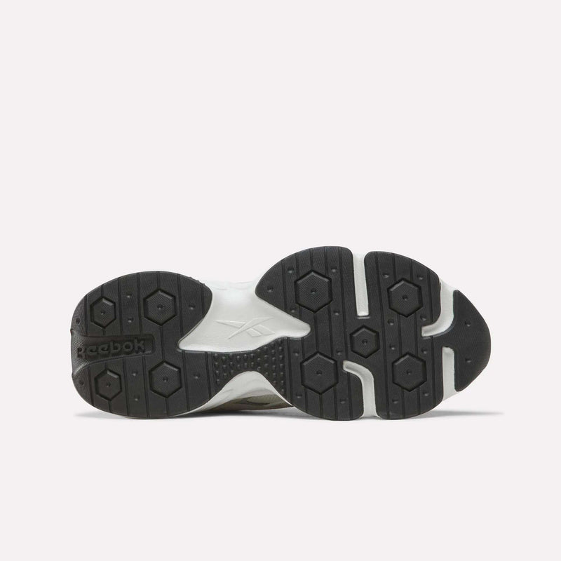 The image displays the black and white rubber outsole of the Reebok Women’s Charge Shoes, seen from the bottom, highlighting the tread pattern and featuring the Reebok logo.