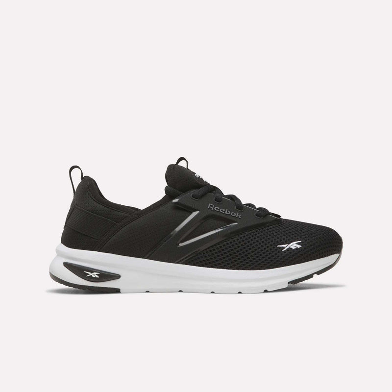 Introducing the Reebok Zome Flare Shoes - Big Kids in black, featuring a breathable mesh upper, contrasting white sole, and white Reebok logos on the heel and toe. Designed for comfort, these kids’ shoes include black laces and a convenient pull tab at the heel for easy on-and-off wear.