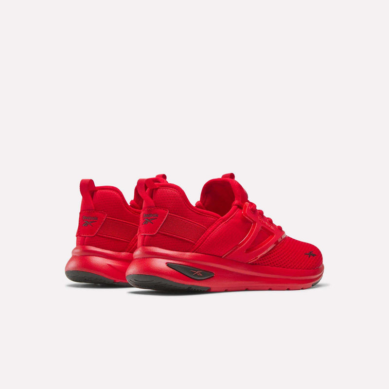A pair of vibrant red Reebok Zome Flare Shoes - Big Kids, featuring black soles and shown from the back left angle on a plain white background—these comfortable Reebok sneakers are ideal for keeping kids active throughout the day.