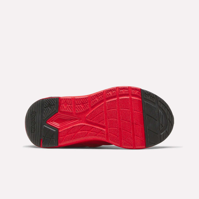 The image shows the red and black sole of the Reebok Zome Flare Shoes for little kids, viewed from the bottom, highlighting its textured pattern and tread design for lightweight comfort.