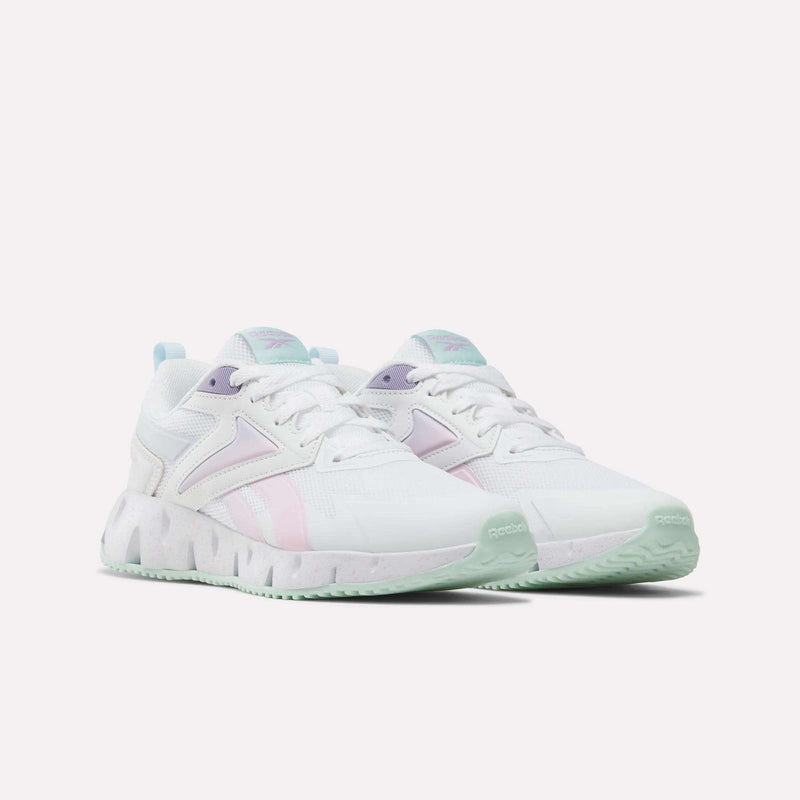 A pair of Reebok Pyro Storm Shoes for big kids in white, featuring pastel purple, pink, and mint green accents with chunky soles and a modern design, set against a plain white background.