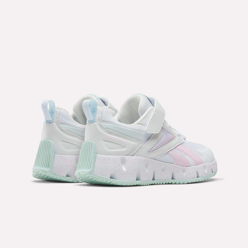 A pair of Reebok Pyro Storm Shoes for big kids in white, featuring pastel green soles, lilac details, and pink accents, displayed at a rear angle on a plain white background.