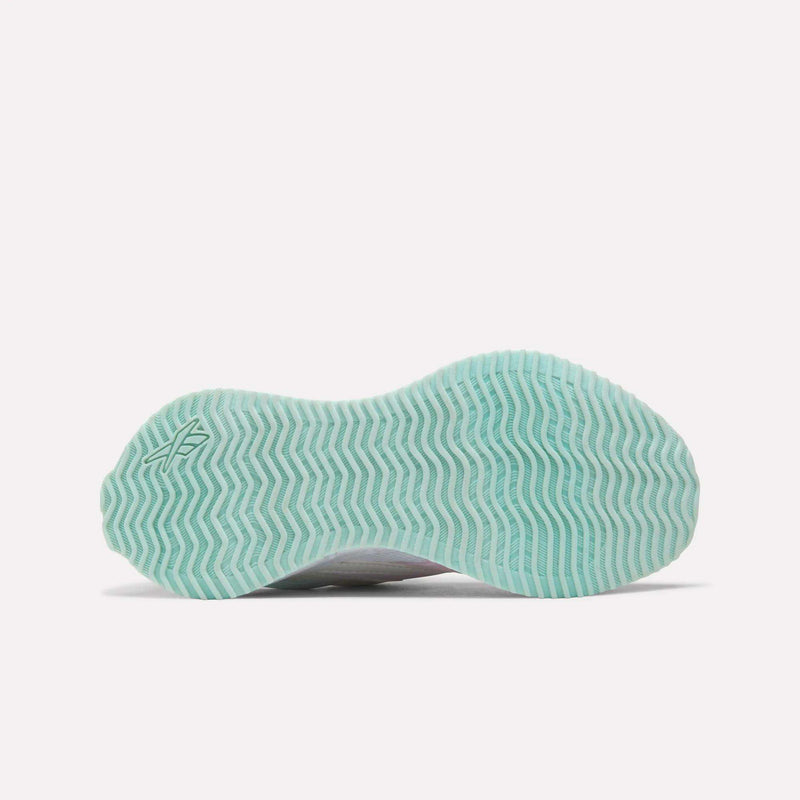 The image displays the teal-colored sole of the Reebok Pyro Storm Shoes for Big Kids, featuring a wavy herringbone tread pattern and a small logo on the left side.