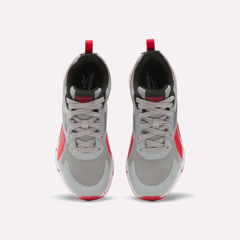A top view of the Reebok Pyro Storm Shoes - Big Kids shows their gray mesh uppers with bold red accents on the sides and soles, plus matching red pull tabs at the heels, highlighting a lightweight design ideal for active kids.