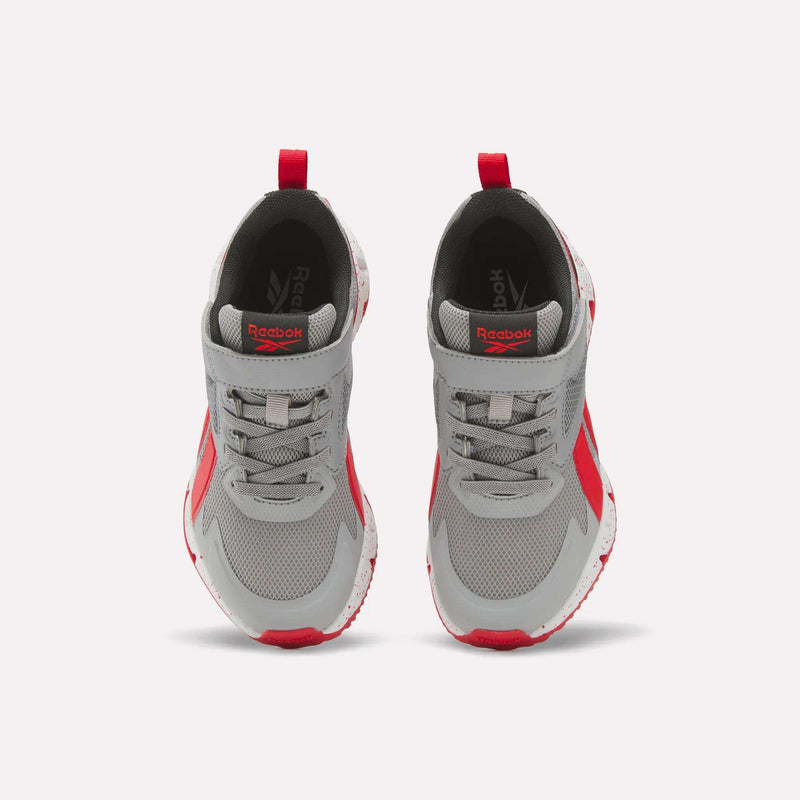 A pair of Reebok Pyro Storm 1V Shoes for little kids in gray with bold red accents are shown from above, highlighting their breathable mesh uppers and white soles. These athletic shoes are positioned side by side on a plain white background, clearly displaying the durable rubber outsole that ensures long-lasting wear.
