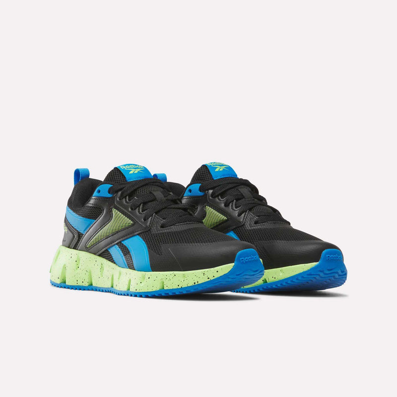 A pair of Reebok Pyro Storm 1V Shoes for little kids in black with blue accents and bright green speckled soles, featuring a durable rubber outsole, displayed against a plain white background.