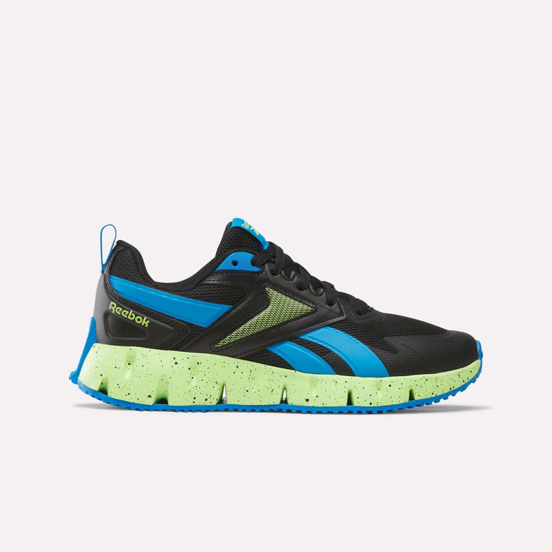 A pair of Reebok Pyro Storm 1V Shoes for little kids in Jet Black, Lime Punch, and Blue Aster is displayed in a side profile against a plain background. These athletic shoes feature blue and neon green accents, including a neon green speckled sole with blue tread, and are designed with a durable rubber outsole to provide long-lasting wear and reliable traction.