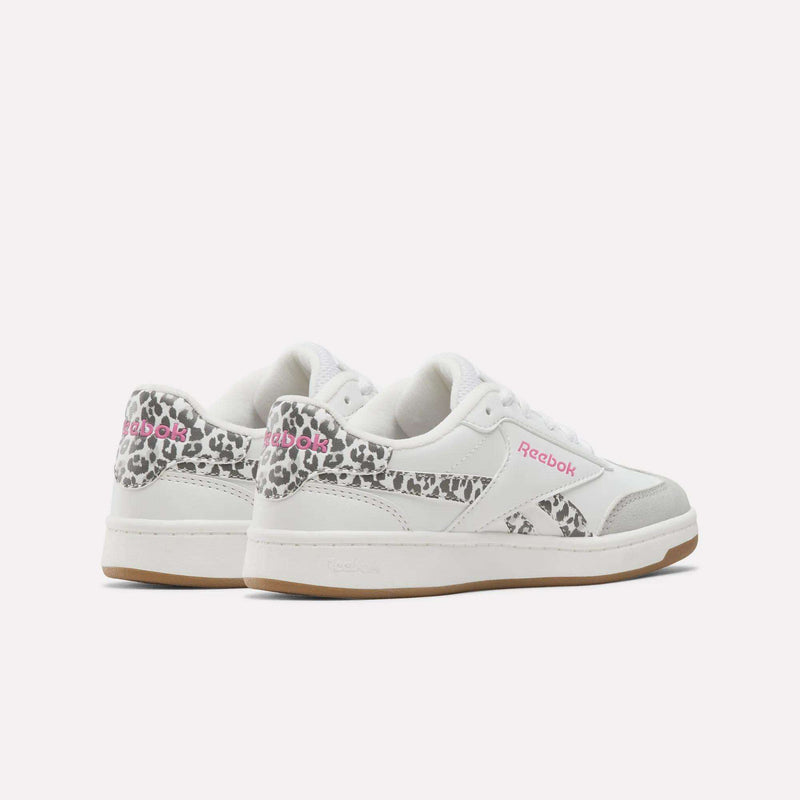A pair of Reebok Forte Pitch Shoes - Big Kids in white, featuring grey accents, pink Reebok logos, and leopard print details on the heel and sides, displayed on a plain white background.