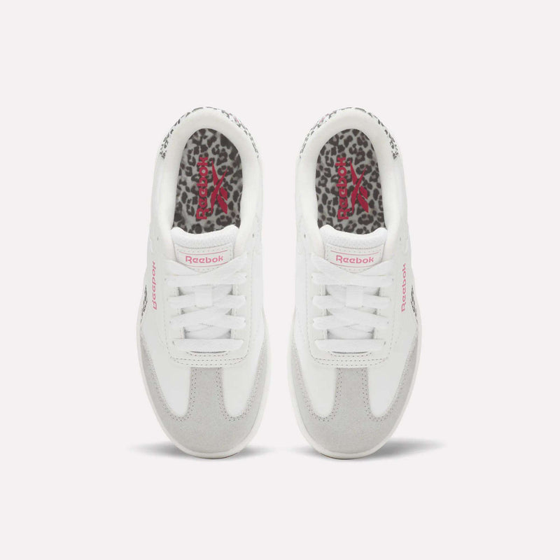 The Forte Pitch Shoes – Big Kids by Reebok, seen from above, feature white uppers with pink Reebok logos and leopard print insoles. The sneakers are placed side by side on a plain light background.