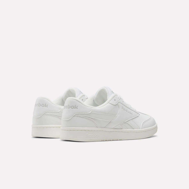 A pair of white Reebok Forte Pitch Shoes - Big Kids are displayed on a plain light background. These court-inspired sneakers showcase a classic low-top design with subtle Reebok branding on the side and heel.