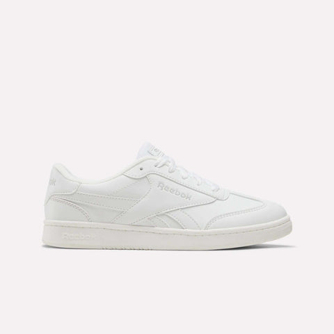 A white Reebok Forte Pitch Shoe for big kids, featuring a low-top silhouette, lace-up closure, and subtle stitched accents is displayed from the side against a plain light backdrop—a contemporary update on court-inspired footwear.