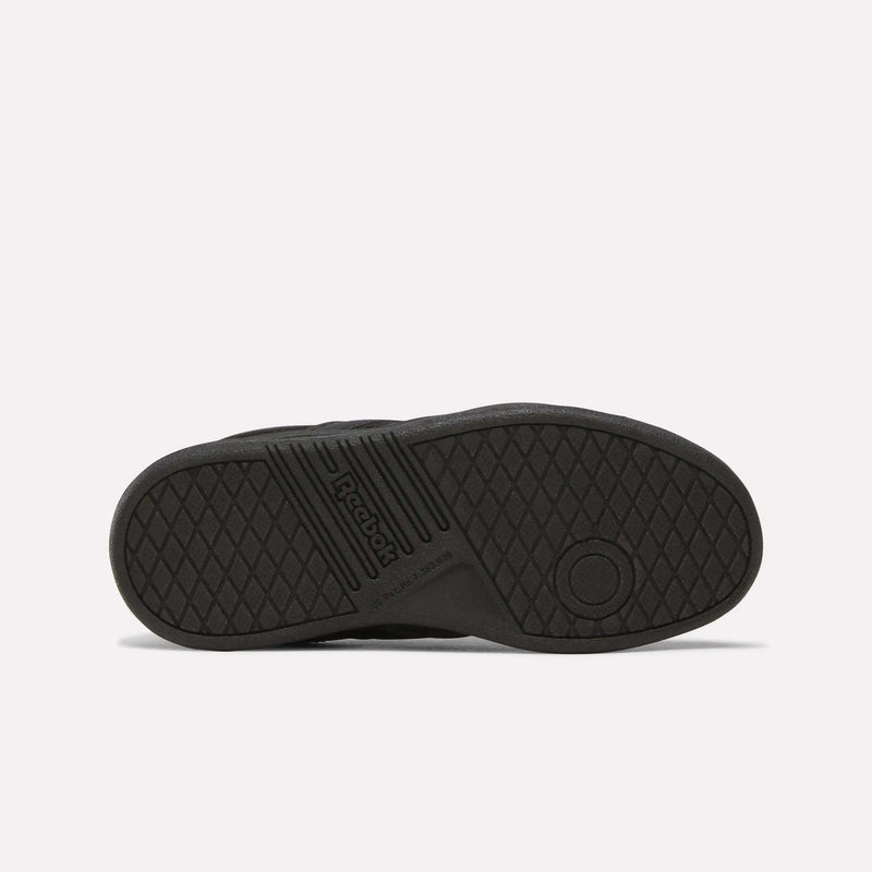 The image features the black rubber sole of the Reebok Forte Pitch Shoes - Little Kids, viewed from underneath. The tread includes diamond shapes, a circular pattern near the heel, and the Reebok logo embossed near the center, reflecting its tennis-inspired design.
