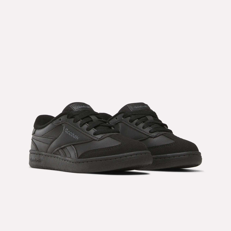 A pair of Reebok Forte Pitch Shoes - Little Kids in black, featuring a low-top, court-inspired design with black laces and subtle Reebok branding on the sides and tongue, displayed on a plain white background.