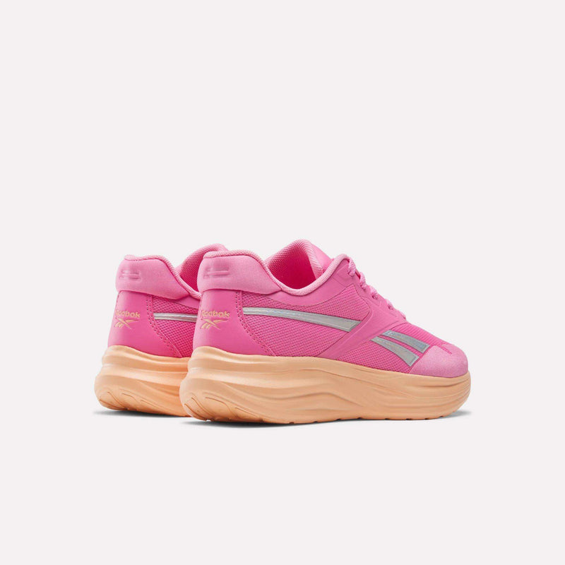 A pair of pink Reebok Blitzr Run 1V Running Shoes - Little Kids with silver side accents and thick orange soles, viewed from the back.