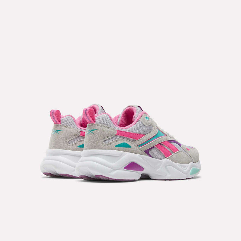 Rear three-quarter view of grey and white Reebok Charge Shoes - Big Kids with bright pink and teal accents.