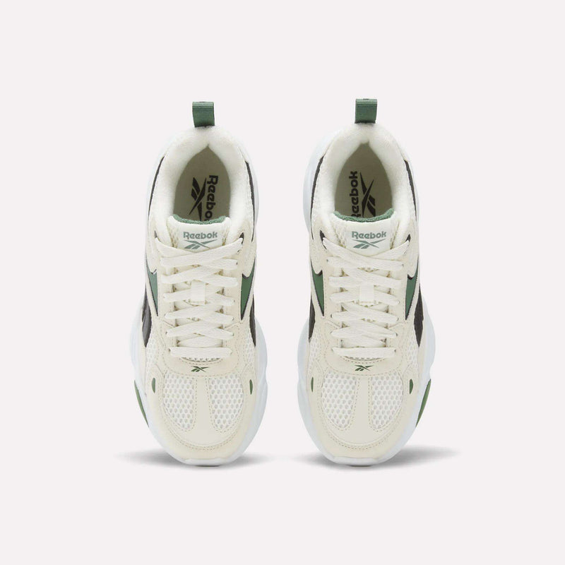 Top-down view of cream-colored Charge Shoes - Big Kids by Reebok, featuring running-inspired design with green accents and white mesh toes.