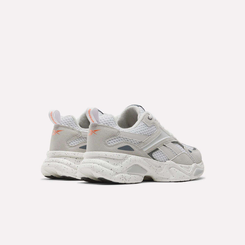 Off-white and grey Reebok Charge Shoes - Big Kids running-inspired sneakers featuring a speckled midsole and orange accent logos on the heel tabs.