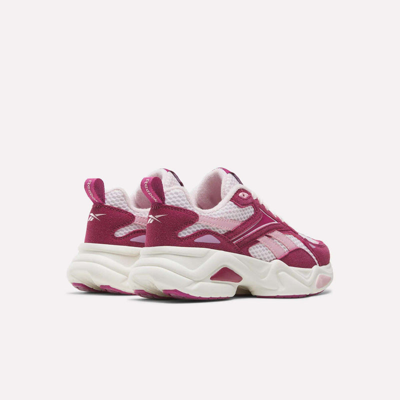 A pair of pink and white Reebok Charge Shoes - Little Kids with thick, chunky, cushioned soles.
