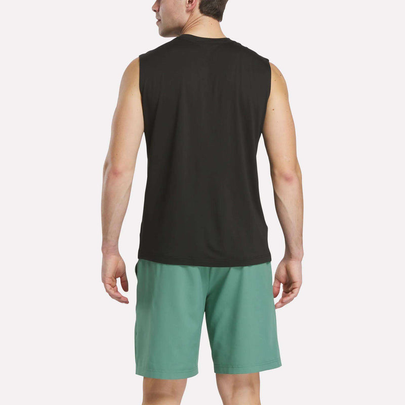 A man stands facing away from the camera, wearing a Reebok Men's Elite Sleeveless Top crafted from cotton flex knit and teal shorts, against a plain light background.