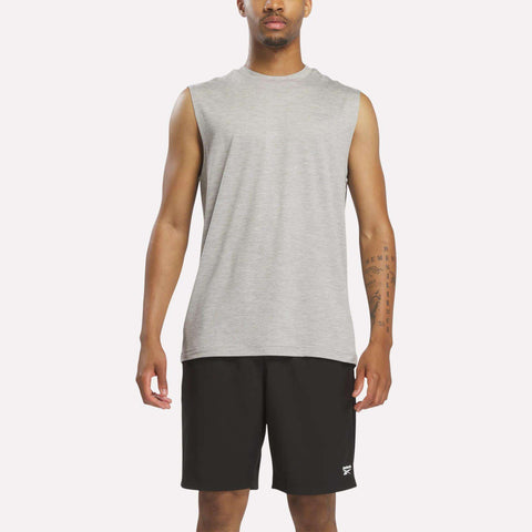 A person wearing a Reebok Men's Elite Sleeveless Top in Grey 2 Heather and black athletic shorts stands facing forward against a plain background.