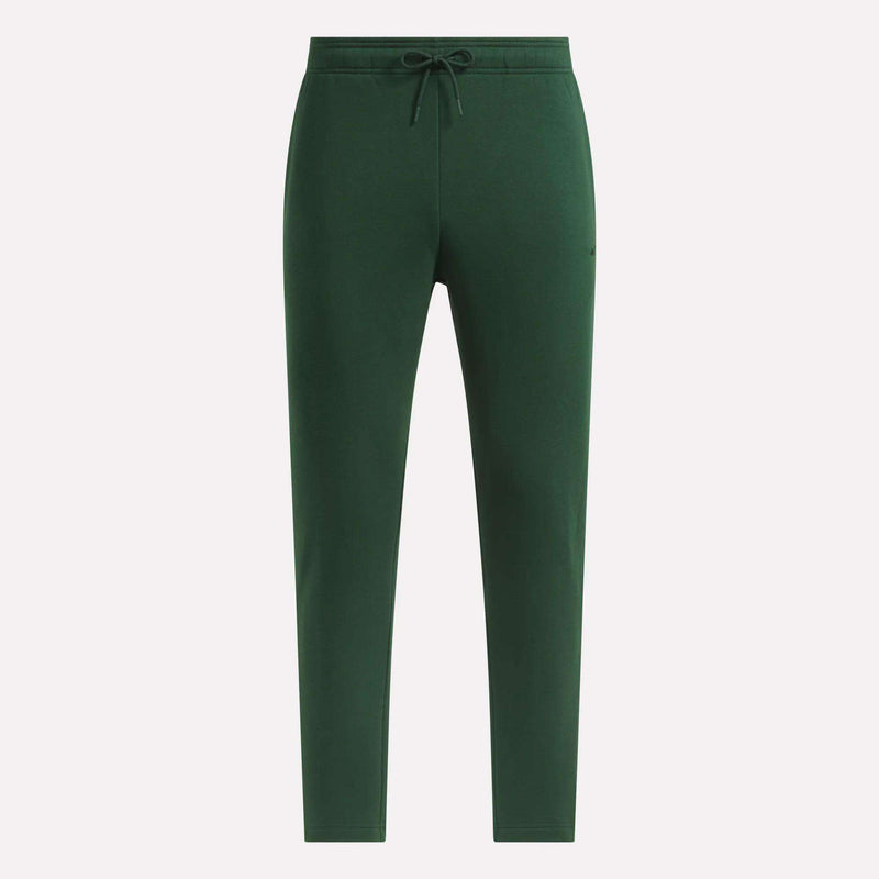 Reebok Men’s Patent Pants in dark green, featuring a slim fit design with an adjustable waistband and tapered legs, shown without visible logos or patterns against a plain white background.