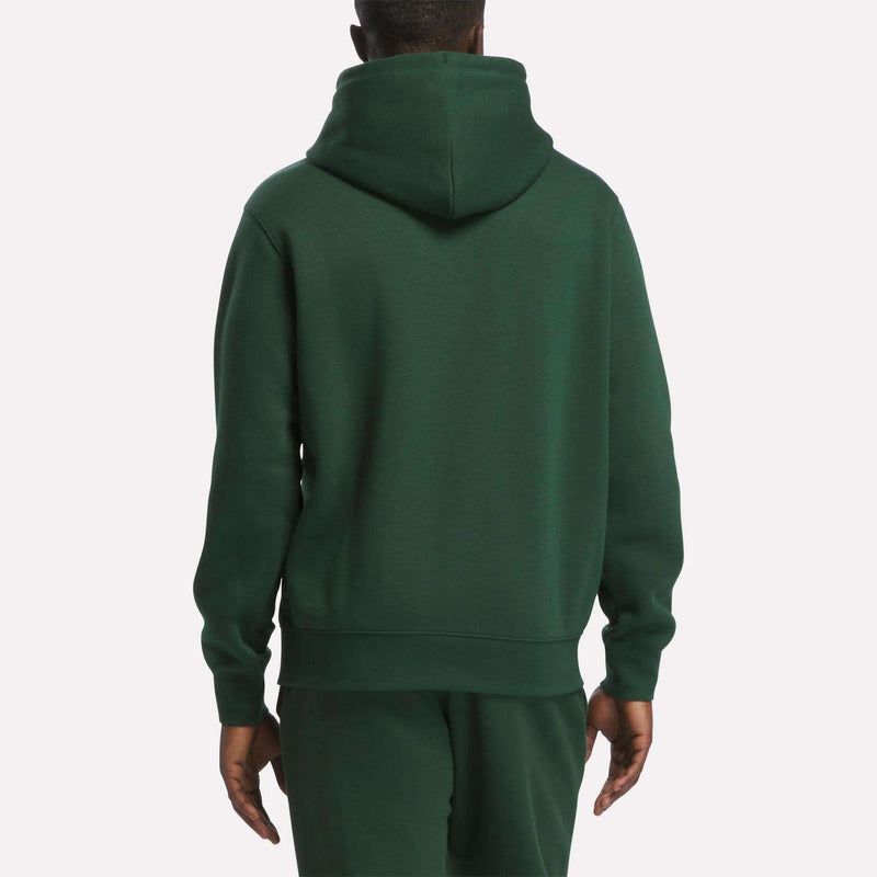 A person is shown from the back, standing against a plain white background and wearing the Reebok Men’s Finisher Hoodie in dark green with matching pants.