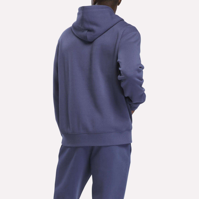 A person is shown from the back, standing against a plain white background, wearing a matching purple Reebok Men’s Finisher Hoodie and sweatpants.