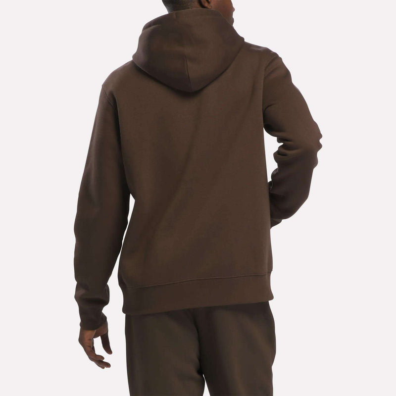 A person is shown from the back, standing against a plain, light background, wearing the Reebok Men’s Finisher Hoodie in a comfortable brown color paired with matching pants.