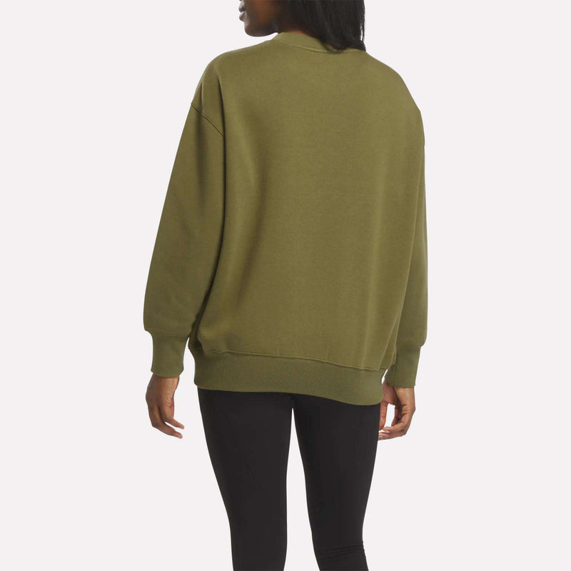 A person wearing the Reebok Women’s Oversized Crewneck Sweatshirt in olive green and black leggings, seen from the back against a white background, highlights its comfortable design.