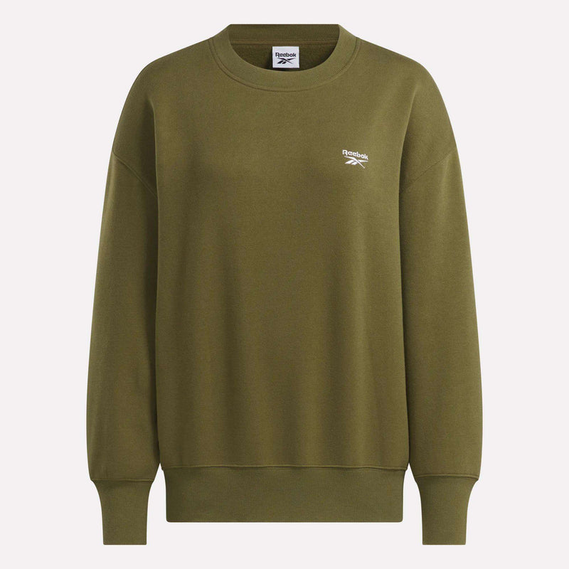 The Women’s Oversized Crewneck Sweatshirt by Reebok comes in olive green with long sleeves, ribbed cuffs and hem, a comfy fit, and a small white Reebok logo on the left chest.
