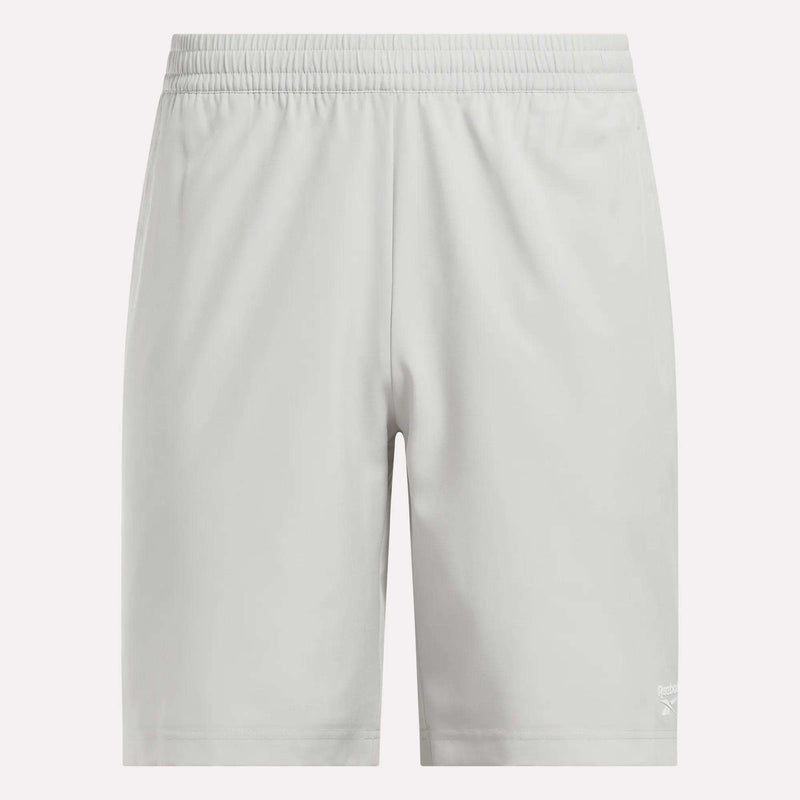 Men’s Range Woven Shorts 9″ by Reebok, shown in light gray with an elastic waistband and a small Reebok logo near the bottom hem on the left leg, are displayed on a plain white background.