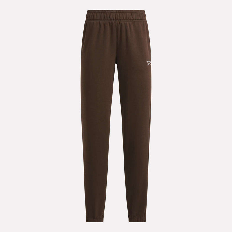 The Women’s Logo Sweatpants by Reebok are brown athletic pants with an elastic waistband and cuffs, highlighted by a small white logo on the left thigh. These sporty sweatpants are photographed against a plain light background.