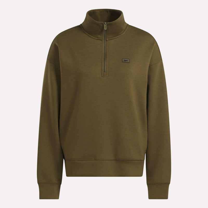 The Women’s Crop Half-Zip Sweatshirt by Reebok is shown in olive green, featuring a high collar, long sleeves, ribbed cuffs and hem, and a small rectangular Reebok logo patch on the left chest. This cropped sweatshirt is displayed against a plain light background.
